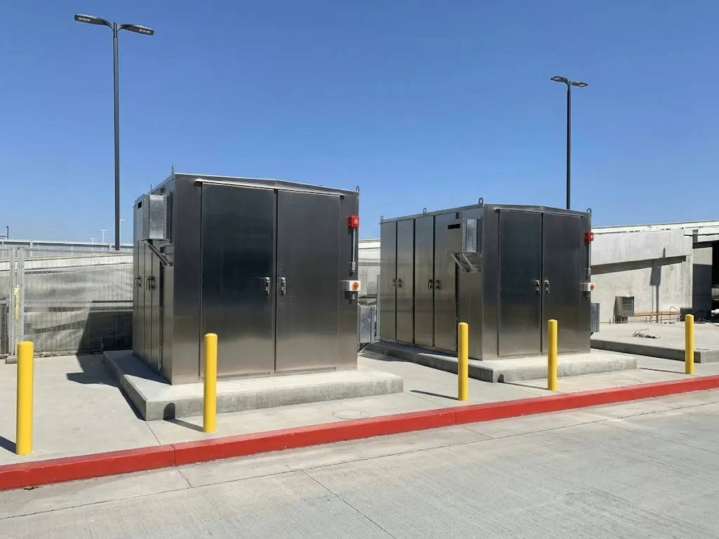 Battery energy storage enclosures behind protective bollards
